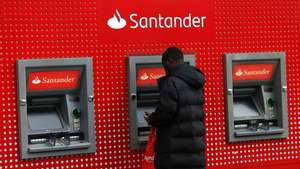 epa10938122 A customer uses a Santander ATM machine at a Santander bank branch in London, Britain, 25 October 2023. Santander has announced soaring third quarter profits at 2.9 billion euros, rising by some twenty percent from the same time last year.  EPA/ANDY RAIN