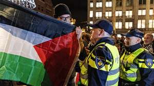 epa11719104 Police officers talk to a pro-Palestinian protester at Dam Square in Amsterdam, the Netherlands, 13 Novermber 2024. The protest took place while an emergency ordinance and demonstration ban were in place in the city. These measures were previously deployed following tensions and violence involving supporters of Israeli soccer club Maccabi Tel Aviv after a soccer match at Ajax on 07 November 2024.  EPA/RAMON VAN FLYMEN