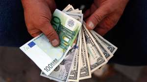 epa06951405 An Iranian street money exchanger holds US dollars and Euro banknotes at a street in Tehran, Iran, 15 August 2018. Media reported that Iran currency continue losing against US dollar and major western currencies. US has re-imposed sanctions against Iran on 06 August 2018 and conflict between Iran and US still going on, as Iran facing economic crises.  EPA/ABEDIN TAHERKENAREH