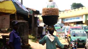 epa08878185 A woman hawks a locally made snack wrapped in a polythene in a bowl, along a street in Sapon district in Abeokuta, Nigeria, 11 December 2020. In the last weeks, the Nigerian currency has witnessed a monumental devaluation to the US dollars, especially in the black market and the prices of goods in the local market are astronomically high.  EPA/AKINTUNDE AKINLEYE