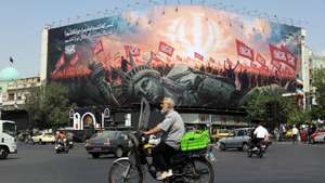 epaselect epa13147977 Iranians drive past an anti-US billboard at Enghelab Square in central Tehran, Iran, 03 August 2026. Tensions between Iran and the US over the Strait of Hormuz continue, as US President Donald Trump said negotiations will take place on 03 August 2026.  EPA/ABEDIN TAHERKENAREH RESTRICTIONS: NO Access Israel Media/Persian Language TV Stations Outside Iran/Strictly No Access BBC Persian/VOA Persian/Manoto TV/Iran International TV. (As mandated by Iran's Directorate General for Foreign Media) --