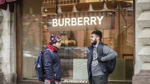 epa10973109 Foreign tourists speak to each other in front of logo of Burberry on a shop-window of closed Burberry retail store in the State Department Store GUM at the Red Square in Moscow, Russia, 13 November 2023. As  EPA/YURI KOCHETKOV