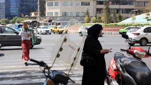 epa12307782 Iranian women walk in a street in Tehran, Iran, 18 August 2025.  EPA/ABEDIN TAHERKENAREH