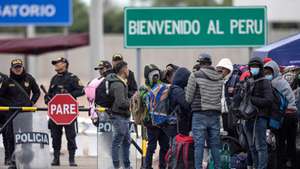 epa10611357 Migrants gather at the Chacalluta border crossing before a planned repatriation flight to Venezuela, in Arica, Chile, 05 May 2023.  EPA/Lucas Aguayo Araos