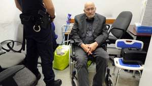 epa06025544 German extreme right political activist and fugitive Horst Mahler, wanted by the German authorities, is guarded by a Hungarian policeman as he waits to be handed over to German police officers at Budapest Liszt Ferenc International Airport in Budapest, Hungary, 13 June 2017. Hungarian authorities have extradicted Mahler, 81, to the authorities of Germany where he was sentenced to ten years in jail for the denial of Holocaust in 2009. In 2015 he was set free due to health problems and was expected to return to jail early 2017 but he ran away and was finally caught by Hungarian police officers in Sopron, Western Hungary, on 15 May.  EPA/ZOLTAN MIHADAK HUNGARY OUT