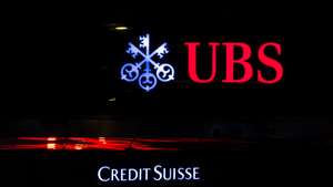 epa10529298 The illuminated logos of the Swiss banks Credit Suisse and UBS are displayed on buildings in Zurich, Switzerland, 18 March 2023. Shares of Credit Suisse lost more than one-quarter of their value on 15 March, hitting a record low after its biggest shareholder, the Saudi National Bank, told outlets that it would not inject more money into the ailing Swiss bank.  EPA/MICHAEL BUHOLZER