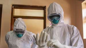 epa10255231 Ugandan doctors wear their Personal Protective Equipments at the Entebbe Regional Referral Hospital Isolation Centre in Entebbe, Uganda, 20 october 2022. A total of 64 positive cases and 24 deaths have so far been confirmed in Uganda since the outbreak of the deadly Ebola virus a month ago in Uganda.  EPA/ISAAC KASAMANI