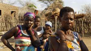Family members of a woman with AIDS pose for a photo outside the woman's hut 05 November in Cachembe village. Most people with AIDS in villages wait until they are very sick to go to hospital. A group of mothers gather at a community meeting under a Baobab tree in the center of the village of Cachembe 05 November 2003. Cachembe school has 1000 students and  200 of them are orphans. Mozambican President Joaquim Chissano last week asked Brazil for aid to help his southern African country combat a devastating HIV/AIDS epidemic. Chissano said that the proposed construction by Brazilian firms of a pharmaceutical laboratory in Mozambique to produce generic AIDS drugs would have the full backing of his government.   AFP PHOTO ALEXANDER JOE