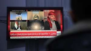 epa12621985 A person watches a TV broadcast on the latest developments in the conflict between Saudi-backed Yemeni government forces and southern separatists, in Sana'a, Yemen, 02 January 2026. State-run Yemen TV reported that the Yemeni government, backed by Saudi Arabia, announced a military operation on 02 January to regain control of military sites in the eastern Yemeni governorates of Hadhramaut and Al-Mahrah, occupied by the Southern Transitional Council (STC) during an offensive last month.  EPA/YAHYA ARHAB