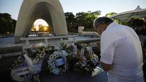 epa09399274 A man prays for the victims in front of a cenotaph at Peace Memorial Park in Hiroshima, western Japan, 06 August 2021. On 06 August 2021, Japan marked the 76th anniversary of the bombing of Hiroshima. This year's annual commemoration events were scaled down amid the ongoing coronavirus pandemic.  EPA/JIJI PRESS JAPAN OUT EDITORIAL USE ONLY/  NO ARCHIVES