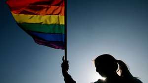 epa02795882 A woman holds a rainbow flag as members of the &#039;Movement of Homosexual Integration and Liberation&#039; (MOVILH) and other activists march through the streets to claim sexual diversity and equality for sexual minorities before the law, Santiago, Chile, on 25 June 2011.  EPA/FERNANDO NAHUEL