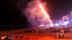 epaselect epa12619706 A man sets off fireworks to celebrate the New Year on the beach in Houhai Village, Hainan Island, China, 01 January 2026.  EPA/ALEX PLAVEVSKI