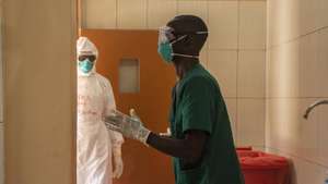 epa10255235 Ugandan doctors dress in their Personal Protective Equipments at the Entebbe Regional Referral Hospital Isolation Centre in Entebbe, Uganda, 20 october 2022. A total of 64 positive cases and 24 deaths have so far been confirmed in Uganda since the outbreak of the deadly Ebola virus a month ago in Uganda.  EPA/ISAAC KASAMANI