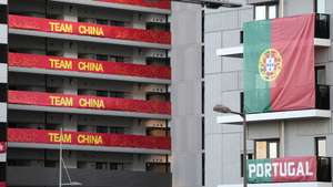 epa09353296 Flags from the Portuguese Olympic team are displayed on buildings hosting Olympic Games participants at the Olympic Village in Tokyo, Japan, 19 July 2021. Just few days before the opening of the Tokyo Games, the Tokyo Olympic Games organizing committee said that 21 people have been certified as close contacts of the three South African men's national soccer team players who have tested positive for COVID-19 and stayed in the Olympic Village.  EPA/FRANCK ROBICHON