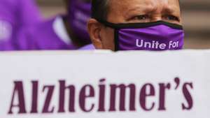 epa08686281 A person wearing a purple mask holds a placard during a gathering on 'World Alzheimer's Day' in Bangalore, India, 21 September 2020. Over fifty people including patients with dementia took part in the event to mark the World Alzheimer's Day held this year under the theme 'Let's talk about dementia'.  EPA/JAGADEESH NV