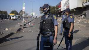 epa09340498 Members of the South African Police Forces try to control looting during protests in Alexandra Township, Johannesburg, South Africa, 12 July 2021. Former South Africa President Zuma was arrested on 07 July, and sentenced to 15 months in prison for contempt of court. Protests by his supporters included shops being looted, burned cars and the blocking of city streets in the country.  EPA/KIM LUDBROOK