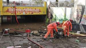 Elementos dos bombeiros usam bombas de escoamento de águas  no acesso pedonal inferior à estação de comboios de Algés, após as inundações da última noite na zona de Lisboa,  08 dezembro 2022, em Algés.   MANUEL DE ALMEIDA/LUSA