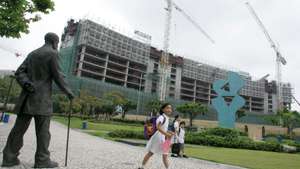 epa000420643 School children returning home walk past the construction site of the new Wynn Resorts casino in Macau, 25 April 2005. Looking on at right is a statue of the Portuguese poet, lawyer and magistrate Camillo Pessanha who died in 1926.Wynn Resorts (WYNN) announced Monday that it has been qualified to participate in the request for the proposal for an integrated resort, to be issued by the Singapore government in the second quarter of 2005. Wynn Resorts plans to open its multibillion-dollar Las Vegas casino resort, Wynn Las Vegas, on April 28 2005, and it's US$700 million Macau casino on the 6.5 hectare site to the public by the autumn of 2006.  EPA/STRINGER