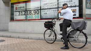 epaselect epa10896731 A man sitting on bicycle looks at a stock market indicator board in Tokyo, Japan, 03 October 2023. Tokyo's Nikkei Stock Average closed lower for a fourth consecutive day amid concerns on the US Federal Reserve interest rates. The yen continued its fall against the US dollar approaching the 150 yen mark for a dollar in the afternoon trading.  EPA/FRANCK ROBICHON