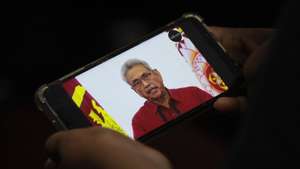 epa10062143 (FILE) - A person watches a video on a mobile phone of Sri Lanka President Gotabaya Rajapaksa addressing the nation on television, in Colombo, Sri Lanka, 11 May 2022 (reissued 09 July 2022). Sri Lankan President Rajapaksa on 09 July 2022 has agreed to resign on 13 July, the parliament's speaker said in a statement after a party leaders' meeting. Thousands of protesters broke through police barricades and stormed the president's official residence during anti-government protest in Colombo. Violent protests have been rocking the country for months over the government's alleged failure to address the worst economic crisis in decades.  EPA/CHAMILA KARUNARATHNE *** Local Caption *** 57671416