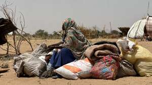 epa12049103 A Sudanese woman, who fled from the internally displaced persons (IDP) Zamzam camp, rests while on her way to the Tawila Camps amid the ongoing conflict between Sudan's army and the Rapid Support Forces (RSF), in North Darfur, Sudan, 23 April 2025. The RSF claimed control of the Zamzam camp after its assault in April 2025. According to the UNHCR, over four million people have fled Sudan to neighboring countries since the outbreak of the armed conflict in April 2023.  EPA/MARWAN MOHAMED
