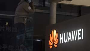 epa09148983 A man stands in front of the Huawei trade fair stand during the first day of the Auto Shanghai 2021 motor show in Shanghai, China, 21 April 2021. The 19th International Automobile Industry Exhibition runs from 24 to 28 April.  EPA/Alex Plavevski