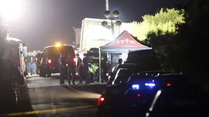 epa10037770 Police and officials man a roadblock near a tractor trailor on the side of the road leading to the location where more at least 46 migrants were reportedly found dead along with at least 15 who were still alive, on a roadway near railroad tracks in San Antonio, Texas, USA, 28 June 2022.  EPA/ADAM DAVIS