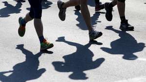 epa07490056 Runners cast shadows on the ground as they participate in the Berlin Generali half-marathon through the center of the capital, Berlin, Germany, 07 April 2019. Over 35,000 people took part in the event.  EPA/FELIPE TRUEBA