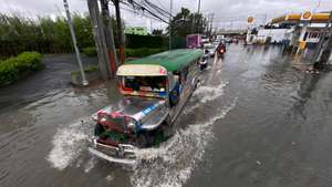 epa10272566 A Jeepney, a popular and uniquely Filipino mode of mass transport, drives through a flooded road in Las Pinas city, Metro Manila, Philippines, 29 October 2022. Data from the National Disaster Risk Reduction and Management Council (NDRRMC) showed that 45 people died from the effects of Typhoon Nalgae as of 29 October. Tracking by the country’s weather bureau places the typhoon in the southern Luzon region moving in a west southwestward direction.  EPA/FRANCIS R. MALASIG