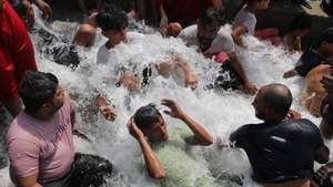 epa11381760 Indian people take bath in water which was flowing into a lake on hot day in New Delhi, India, 31 May 2024. The India Meteorological Department (IMD) has issued a heat red alert for Delhi, Rajasthan, Haryana, Punjab, and Madhya Pradesh. The IMD Director General M Mohapatra said they are checking the temperature sensor in Delhi's Mungeshpur automatic weather station to see if it is working properly, as there were temperatures of over 50 degrees Celsius recorded on 29 May, and the weather department has reported that the maximum temperature is anticipated to reach around 44 degrees Celsius, in the Indian capital.  EPA/RAJAT GUPTA