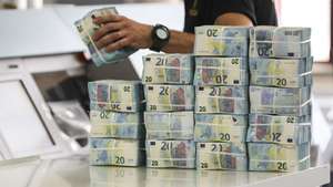 Um funcionário manuseia pacotes de notas de 20 Euros no complexo do Banco de Portugal, durante a iniciativa que marca o encerramento das comemorações dos 20 anos do Euro, no Carregado, 17 de maio de 2022. MIGUEL A. LOPES/LUSA