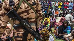 epa09155836 A Chadian soldier stands guard as a crowd gathers to witness the state funeral for the late Chadian president Idriss Deby in N'Djamena, Chad, 23 April 2021. Chad's President Idriss Deby died of injuries suffered in clashes with rebels in the country's north, an army spokesperson announced on state television on 20 April 2021. Deby had been in power since 1990 and was re-elected for a sixth term in the 11 April 2021 elections. The state funeral took place on the morning of 23 April 2021, attended by French President Emmanuel Macron.  EPA/CHRISTOPHE PETIT TESSON / POOL