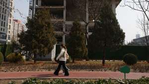 epa12824519 People walk past an unfinished building in Beijing, China, 16 March 2026. According to the National Bureau of Statistics, new home prices in 70 cities fell 3.2 percent year‑on‑year in February 2026, marking the 32nd consecutive month of contraction and the largest drop since June.  EPA/JESSICA LEE
