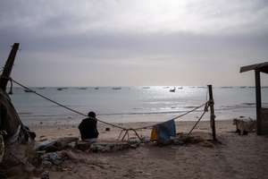 epa11846368 A young man sits on the beach in Bargny, 30 kilometres west of Dakar, Senegal, 17 January 2025 (issued 23 January 2025). In October 2023 from this location, a pirogue with over 100 would-be migrants left Senegal for Spain in search of better opportunities and disappeared forever. 'Nobody (of the more than a hundred who were travelling on the boat) has been recovered,' said local resident Binata Dieng, whose 19-year-old daughter was on board. According to figures from the European Border and Coast Guard Agency (Frontex), more than 87,000 people arrived in Spain via the Atlantic route in 2023 and 2024, coming not only from Senegal but also from countries such as Mauritania and Gambia. In Bargny, the local government estimates that nearly 3,000 people from the settlement have taken this migratory route in the last two years. Bargny symbolises one of the greatest tragedies of emigration and the intersection between environmental deterioration and socio-economic fragility in coastal cities in Senegal.  EPA/JEROME FAVRE