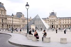 epa13119373 People enjoy the surrondings of the Louvre Museum in Paris, France, 18 July 2026.  EPA/TERESA SUAREZ