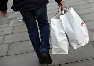 epa05685747 A man carries shopping bags along New Bond Street in London, Britain, 22 December 2016. Retailers are expecting a rush of shoppers in the lead-up to Christmas, with stores preparing for a record-breaking Christmas Eve shopping spree in the capital.  EPA/HANNAH MCKAY