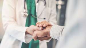 Médico segura mão de doente