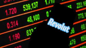 In this photo illustration a logo Revolut seen displayed on