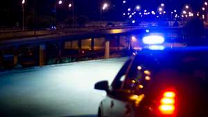 Police car with bright sirens and the city in the background