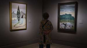 A visitor observes the works of the exhibition "The Magritte