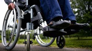 Man in wheelchair on path in park, low section
