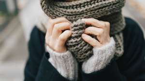 Woman&#039;s hand holding knitted scarf, close-up