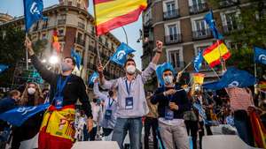 Supporters of Popular Party (PP) waving flags as they follow