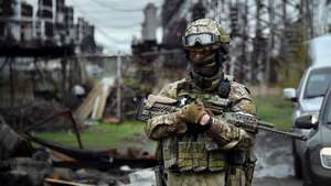 In this picture taken on April 13, 2022, a Russian soldier stands guard at the Luhansk power plant in the town of Shchastya.