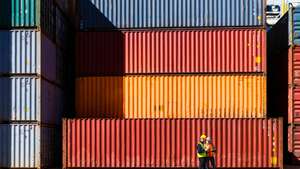 Workers having discussion against cargo containers