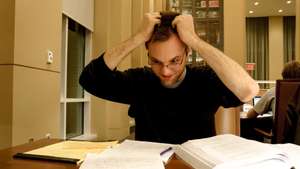 A flustered college student grabs his hair as he looks at his notes in the Reading Room of the Brody Learning Commons, a study space and library on the Homewood campus of the Johns Hopkins University in Baltimore, Maryland, 2015. Courtesy Eric Chen. (Photo by JHU Sheridan Libraries/Gado/Getty Images).