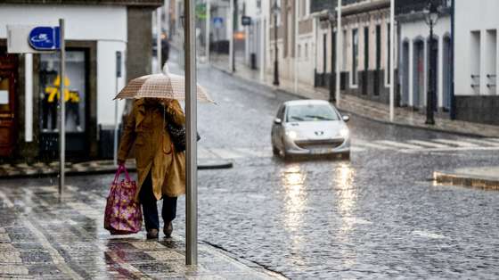 Uma popular protegida por um guarda-chuva passa pela rua do Galo, deserta de pessoas, devido aos efeitos que já estão a ser sentidos, com o aumento gradual do vento e chuva nos grupos central e oriental do arquipélago dos Açores, da passagem do furacão Alex, na Praia da vitória, Ilha Terceira, 15 de janeiro de 2016. Segundo o IPMA  Instituto Português do Mar e da Atmosfera, o período mais crítico ocorrerá entre as 08:00 e as 11:00 de hoje (hora local, menos uma hora do que em Lisboa), quando se prevê a sua passagem em cima do arquipélago. ANTÓNIO ARAÚJO/LUSA