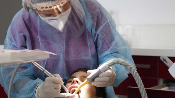 epa08416579 Dentist Alexandra Smooth, wears personal protect equipement, due to the coronavirus pandemic, as she works on a patient at her practice in Gignac, France, 12 May 2020. According to media reports, on 11 May 2020, France began to ease coronavirus restrictions, after 55 days of total lockdown.  EPA/GUILLAUME HORCAJUELO