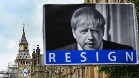 epa09999155 A protester holds up an anti Boris Johnson placard outside parliament in London, Britain, 06 June 2022. British Prime Minister Boris Johnson is facing a 'vote of no confidence' to determine whether he should remain in his position. Conservative Party MP's will vote in parliament on whether to keep Johnson as their leader on 06 June.  EPA/ANDY RAIN