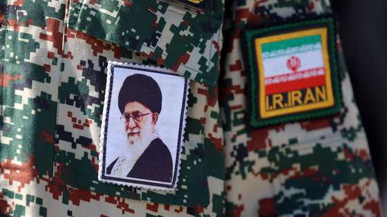 epa12781506 An Iranian man has a photograph of the Iranian supreme leader Ali Khamenei stitched to his uniform while leaving after the Friday prayer ceremony at the Mosallah mosque in Tehran, Iran, 27 February 2026. Iran and the US are holding another round of talks in Geneva amid ongoing tension.  EPA/ABEDIN TAHERKENAREH